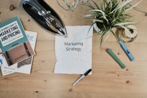A white piece of paper on a desk with ''marketing strategy'' written on it