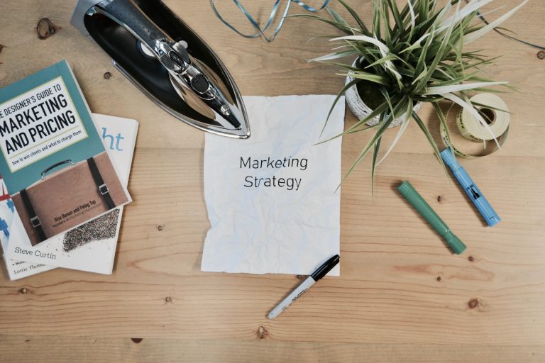 A white piece of paper on a desk with ''marketing strategy'' written on it