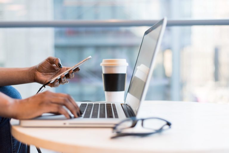 Entrepreneur working with their computer and phone at the same time.